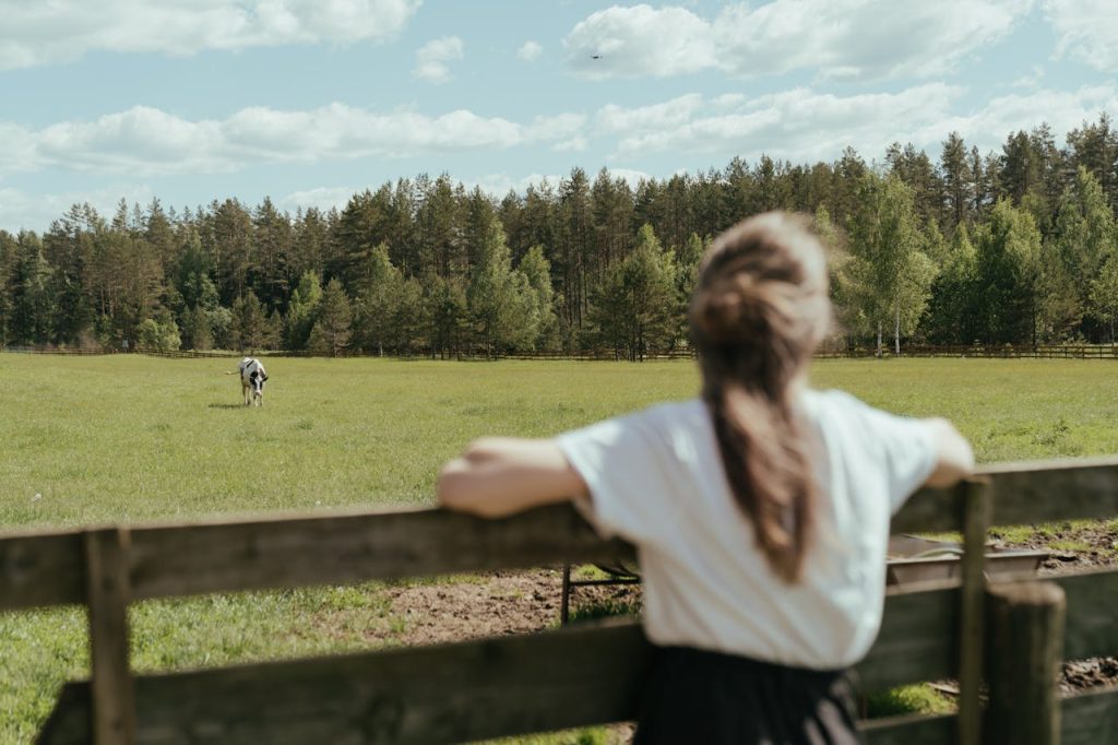Woman in White T-shirt Standing on Green Grass Field